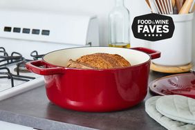 A red Goldilocks Dutch Oven Review sits on a kitchen counter top.