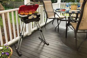 The Cuisinart’s Portable Gas Grill on a deck next an outdoor dining set.