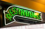 A neon "restrooms" sign at a restaurant