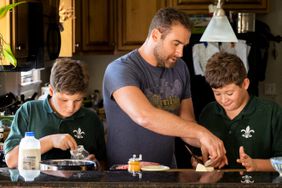 Chef Michael Gulotta and his twin sons, Ethan and Liam, cooking at home