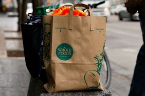 A shopper waits for a taxi outside a Whole Foods grocery store 